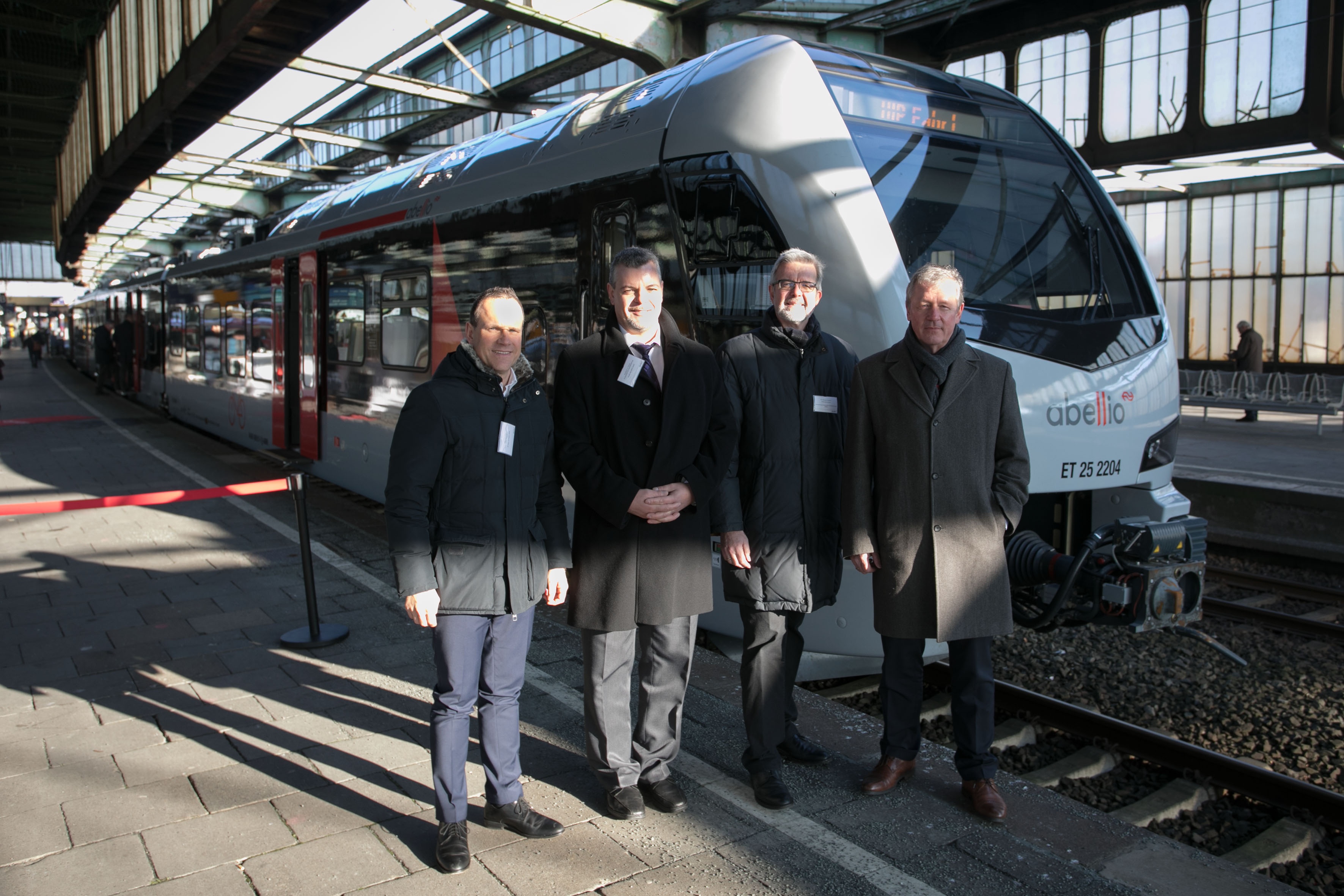 Von links: Dirk Schnurbus (DB Regio NRW), Ronald R. F. Lünser (Abellio Rail NRW), Dr. Hermann Paßlick (NWL) und Martin Husmann (VRR) freuen sich, bei der ersten Fahrt mit dem neuen Fahrzeug im Niederrhein-Netz dabei zu sein. (Foto: © Abellio)